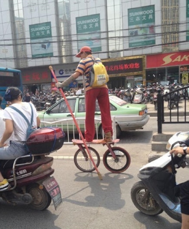 ชายชาวจีนซิ่งพาหนะสองล้อลูกผสมระหว่างเก็ตบอร์ดและจักรยานได้อย่างคล่องแคล่ว