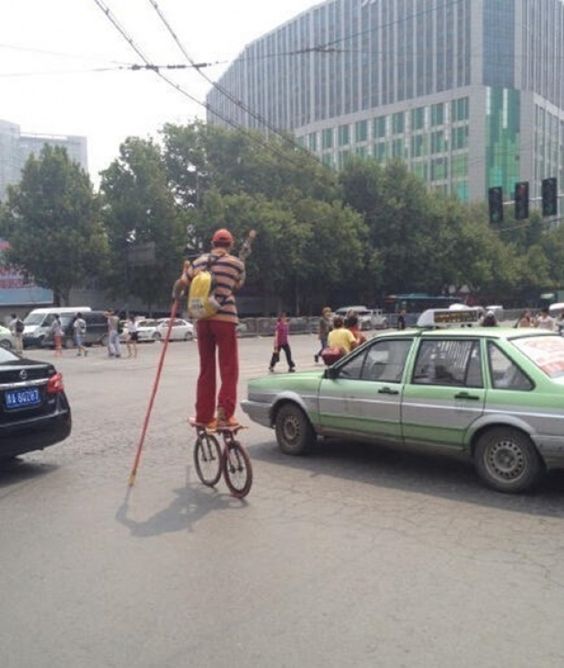 ชายชาวจีนซิ่งพาหนะสองล้อลูกผสมระหว่างเก็ตบอร์ดและจักรยานได้อย่างคล่องแคล่ว
