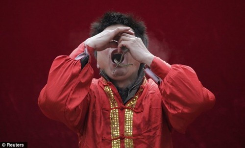 นักแสดงชาวจีน โชว์สอดงูเข้าปากโผล่ออกทางจมูกฉลองปีมะเส็ง