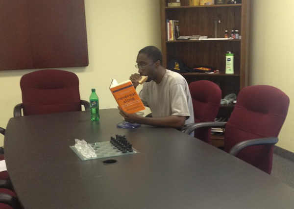 ชายผิวสีคนนี้กำลังอ่านหนังสือ "ไม่เคยกินข้าวคนเดียว"