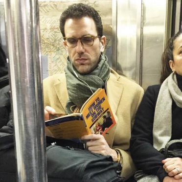 ผู้ชายคนนี้กำลังอ่าน "ทำยังไงถึงจะได้เจอสาวบนรถไฟใต้ดิน"